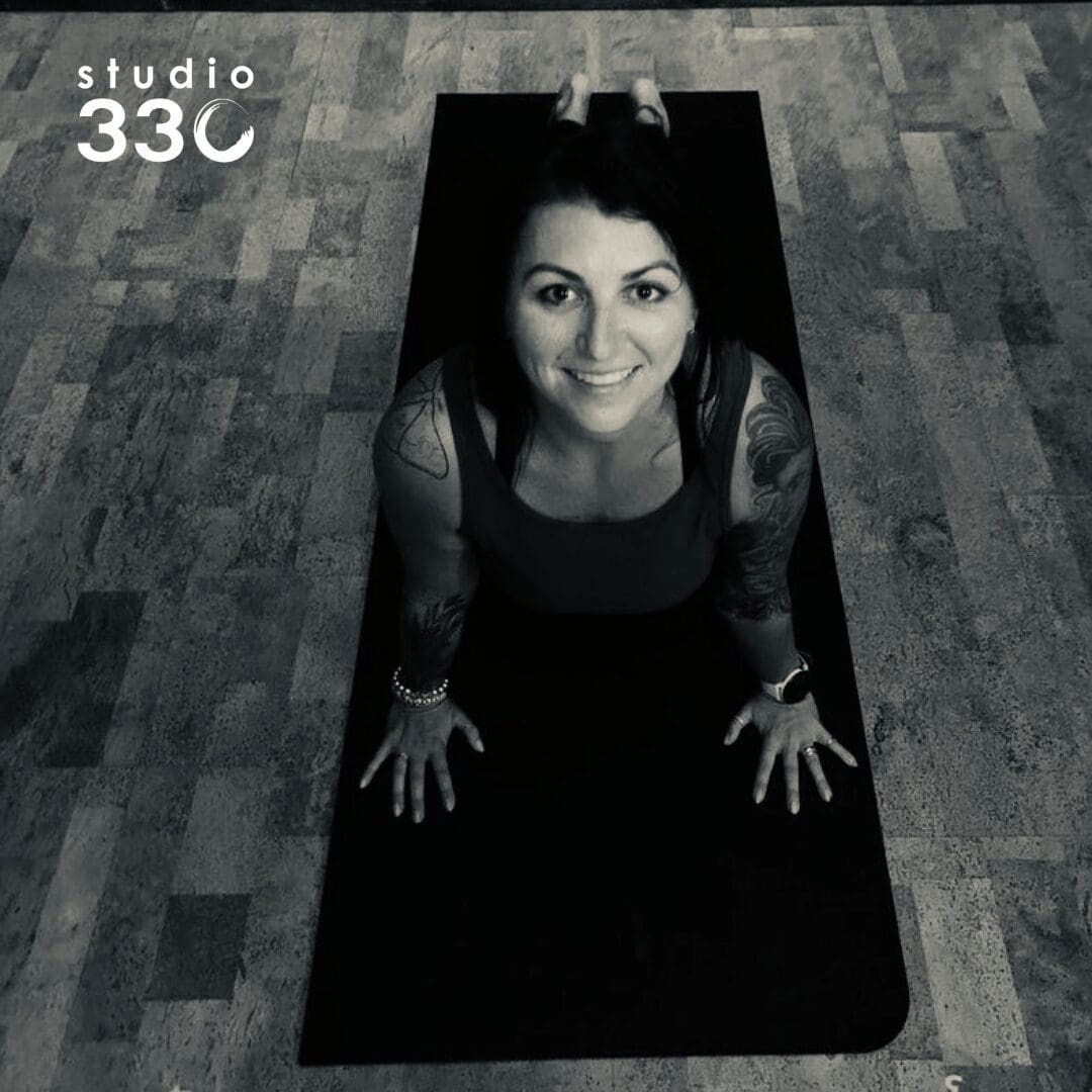 Black and white of Ashley doing upward dog and smiling